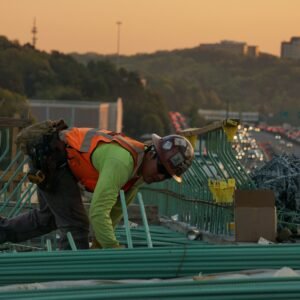 man on green galvanized iron sheet holding green bar